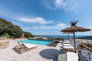 Piscine avec vue mer et parasols en paille à La Perle des Albères, demeure d'exception à Argelès-sur-Mer