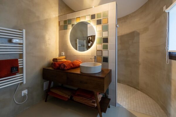 Salle de bain avec double vasque et miroir rond à La Perle des Albères, demeure d'exception à Argelès-sur-Mer