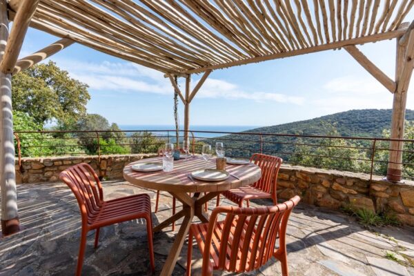 Terrasse sous pergola avec table de repas et vue panoramique à La Perle des Albères, demeure d'exception à Argelès-sur-Mer